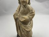 une petite statue représentant un garçon tenant un oiseau, posée sur un socle en bois