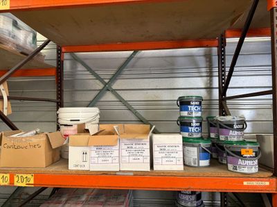 de nombreux cartons de peinture sur une étagère dans un entrepôt
