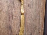 a gold feather shaped object on a wooden table