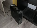 a small black computer on the floor next to a book shelf