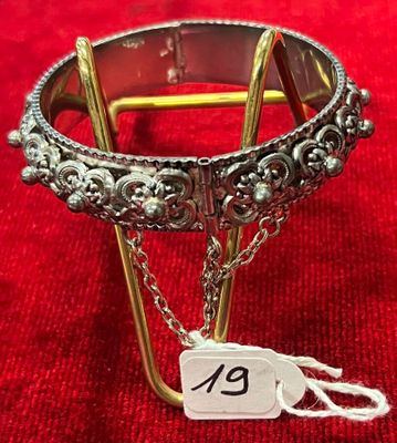 bracelet en argent avec une chaîne et une plaque sur fond rouge