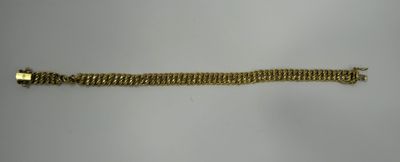 a close up of a gold bracelet on a white surface