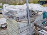 un tas de bois posé par terre à côté d'une clôture