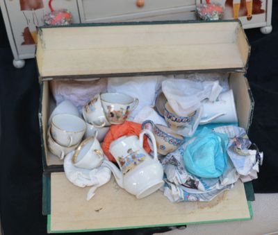une boîte remplie de tasses à thé et de soucoupes sur une table