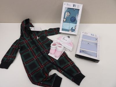 a green and red plaid onesuit and a picture frame on a white table