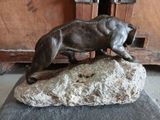 a statue of a dog that is standing on a rock