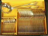 a lot of silverware in a box with a spoon and spoon rest