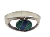 a close up of a silver ring with a green and blue stone