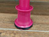 a pink cup sitting on top of a wooden floor