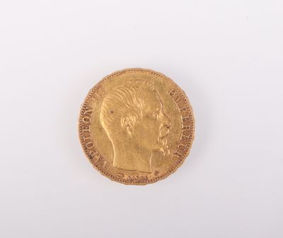 gros plan d'une pièce d'or sur une surface blanche