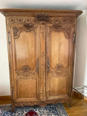 a wooden armoire in the corner of a room