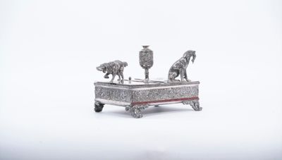 une figurine en argent représentant deux chevaux, posée sur une table