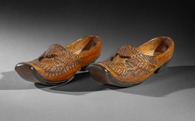pair of wooden clogs with carved design on the toes
