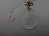 a glass necklace with a gold chain attached to it