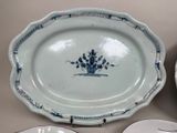 a plate with a blue flower on it next to a plate with a white plate with a blue flower on it