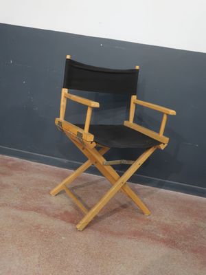 une chaise de réalisateur noire posée dans un coin