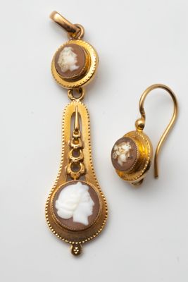 a close up of a pair of earrings on a white surface