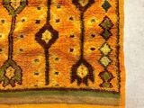an orange rug with a pattern of flowers and leaves on it