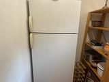 a white refrigerator in the corner of a room