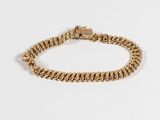 un bracelet à chaîne en or avec un fermoir sur fond blanc
