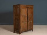 an old wooden cabinet with two doors on top of it