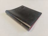 a black book on a white table with a red edge