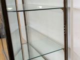 a glass display case in the corner of a room