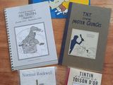 several books on a table with a wooden table in the background