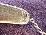 une cuillère en argent à laquelle est attachée une chaîne