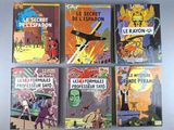 six books of comics are lined up on a white surface