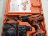 un étui orange contenant une perceuse et deux batteries