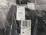 a plastic bag of clothing that has a price tag on it