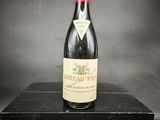 une vieille bouteille de vin posée sur une boîte noire