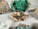 many different colored rocks on a white surface