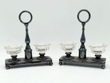 paire de bougeoirs anciens en verre posés sur un socle en fonte