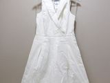 une photo d'une robe blanche suspendue à un cintre