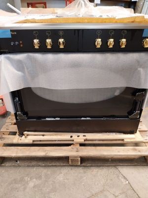 a black oven sitting on a pallet in a room