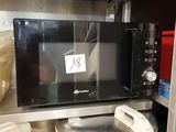 a microwave sitting on top of a shelf in a kitchen