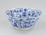 blue and white porcelain bowl with a pattern of flowers and trees