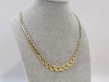 a gold chain necklace on a mannequin display