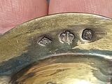 a person holding a silver plate with a ring on it