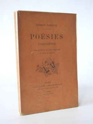 an old book sitting on top of a table next to a white wall