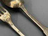 deux cuillères et une fourchette posées sur une table