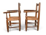 pair of antique wooden chairs with woven seats on white background