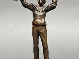 bronze figurine of a man holding a baseball glove and a ball