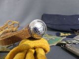 a yellow glove with a silver ball on top of it