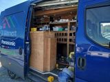 a blue van that has a bunch of boxes inside of it