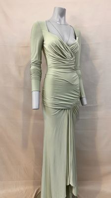 the mannequin is wearing a green dress with long sleeves