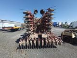 an image of a tractor with a large raker in the middle of a parking lot