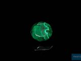 a close up of a green stone on a black surface